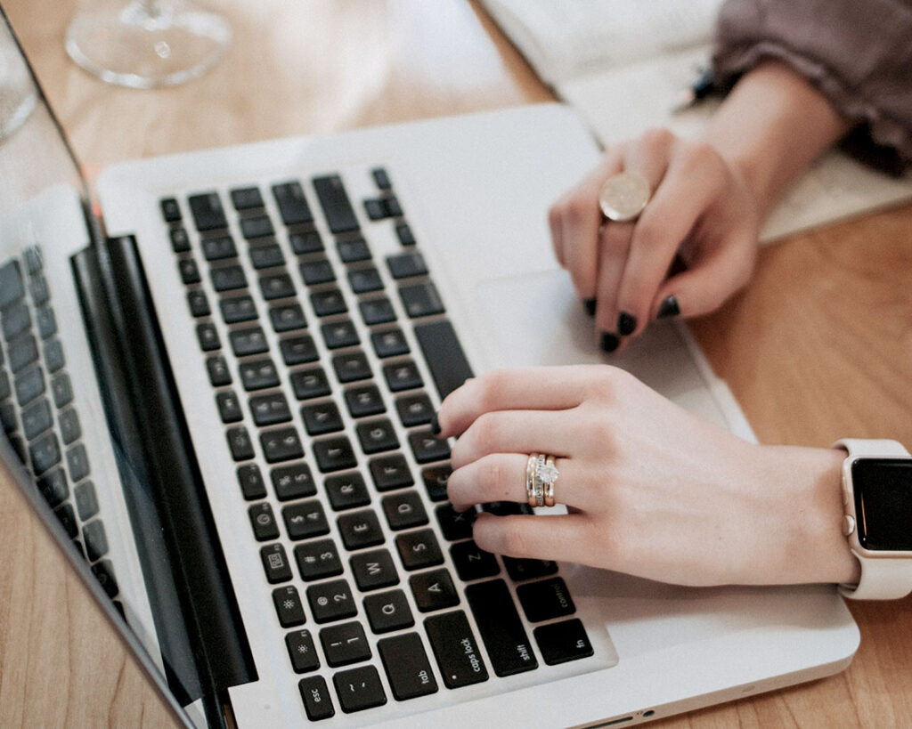 Female hands on a laptop's keyboard.