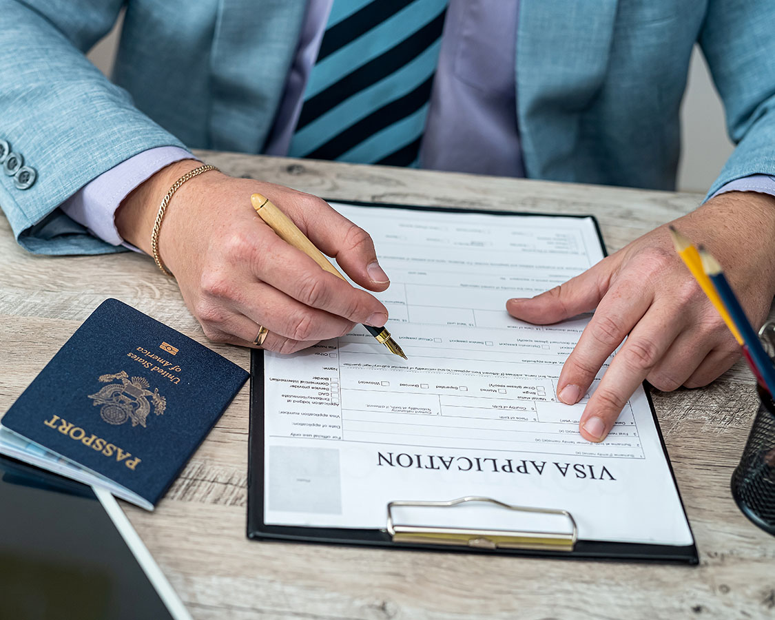 Male hands over an application with pen in one hand.